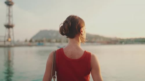 Close-up, girl stands on the seashore and looks at the bay