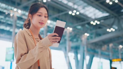 Happy asian tourist woman looking passport in Airport Terminal