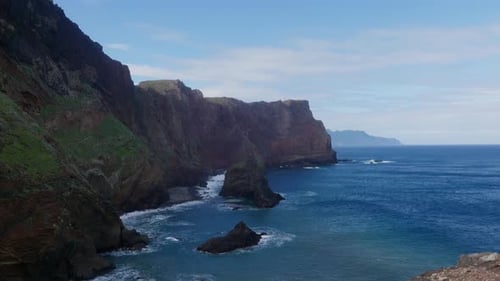 Towering Cliffs Border Wild Churning Ocean with Gusty Wind