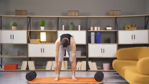 Man Doing Toe Touch Stretches on Yoga Mat