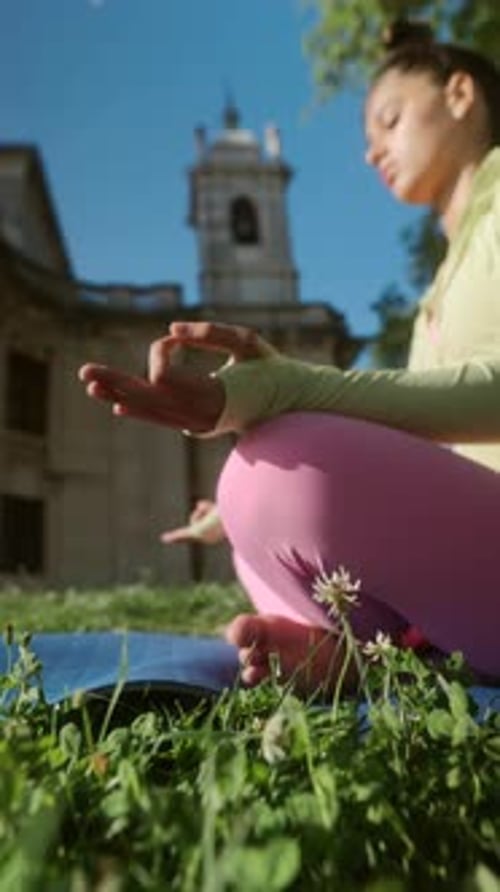 Woman Meditating in a City Park on Sunny Day