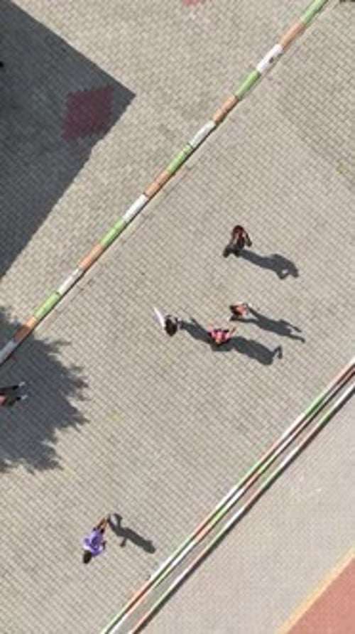 Vertikales Video: Abenteuer auf dem Schulhof, Luftbild von Schülern, die sich mit Fußball und Verspieltheit beschäftigen