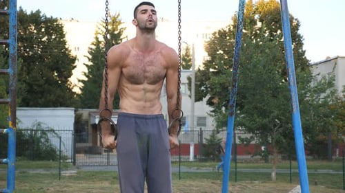 Muscular Man Works Out on Gymnastic Rings