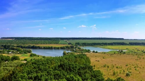 Flying over the beautiful green nature of countryside in summer.