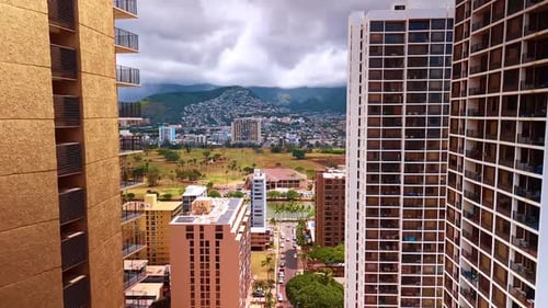 Populated urban area stretching to the slopes of the mountains under the dramatic cloudscape.