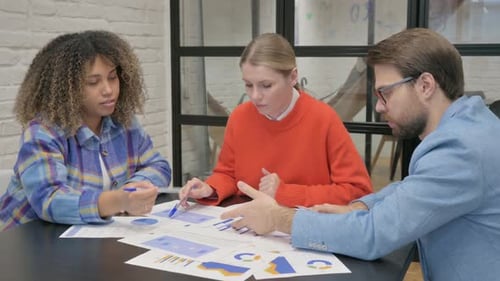 Young People Working on Documents in Office