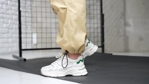 White fashionable shoes for sport. Trendy female footwear presentation in the studio. Close up.