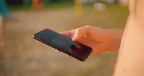Using smart phone outdoors sunny day