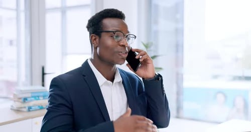 Businessman Talking on Mobile Phone in Bright Office