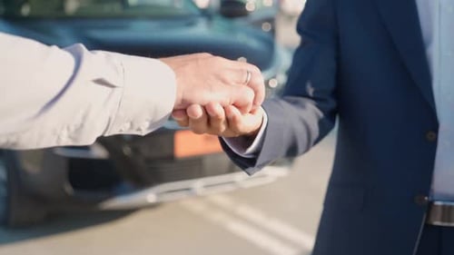 Businessman in Suit Picks Up a Car at the Dealership Dealer Hands Over the Keys to a New Car to the