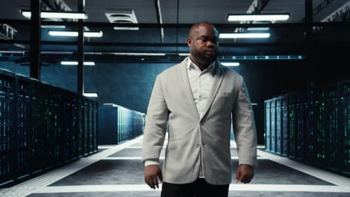 Employee Walking in Data Center with Blinking Lights on Rigs