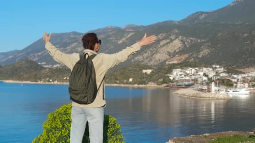Tourist Raising Arms Enjoying Scenic View