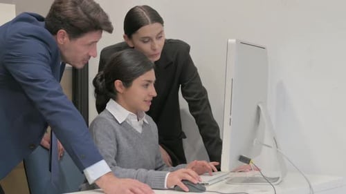 Team Collaborating on a Computer in Office