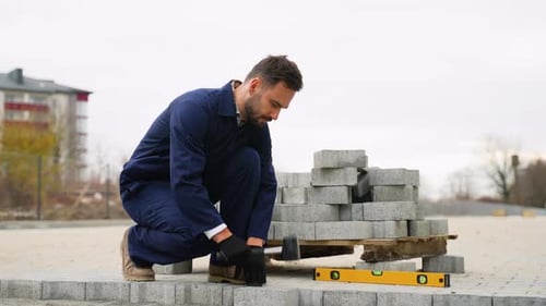Construction Worker Installing Paving Stones on Sidewalk