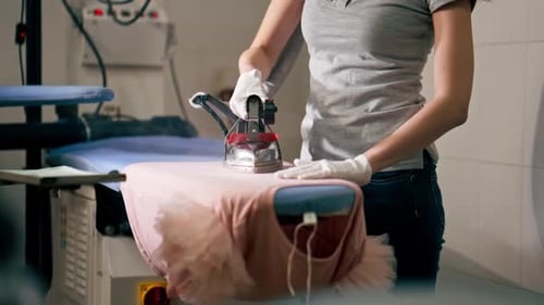Woman Ironing Pink Ruffled Top Professionally