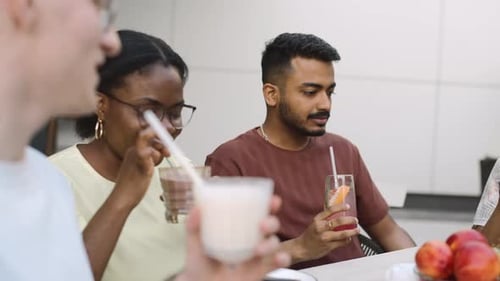 Friends enjoying drinks and fruit at outdoor cafe
