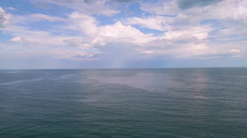 Malerischer Blick auf das ruhige blaue Meer unter dramatisch Himmel mit flauschigen Wolken