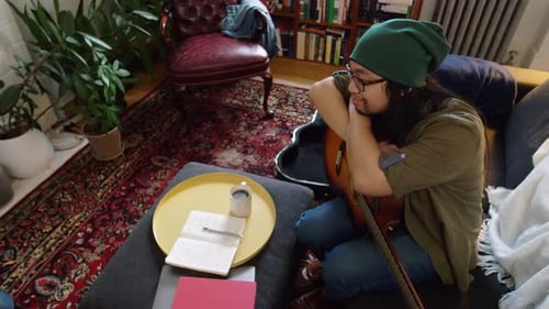 Man with guitar relaxing on couch at home