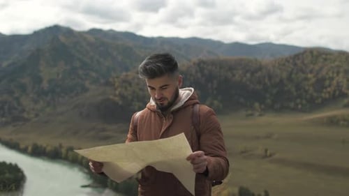 Man Reading a Map in the Mountains