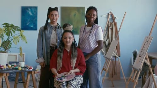 Portrait of Female Artist in Wheelchair with Friends in Modern Painting Studio