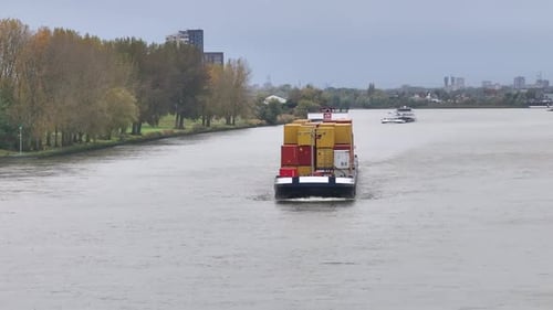 Barge Carrying Containers on River in City