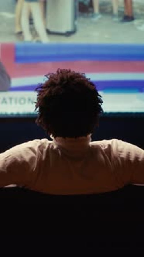 Vertical Video Person Relaxing on Couch Watching VOD Channel on Large Television Set in Living Room