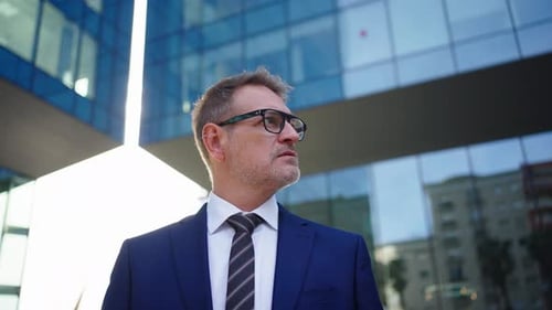 Man in Suit Stands Near Office Building