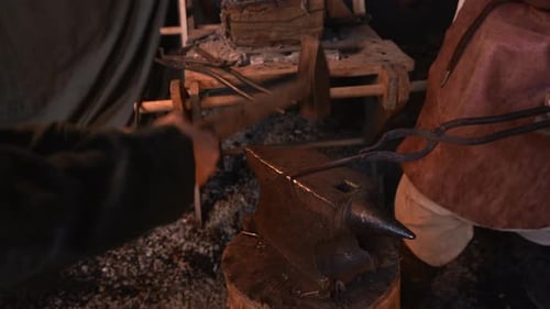 Turning iron. Media. Processionals work to shape the iron in with special hammers.