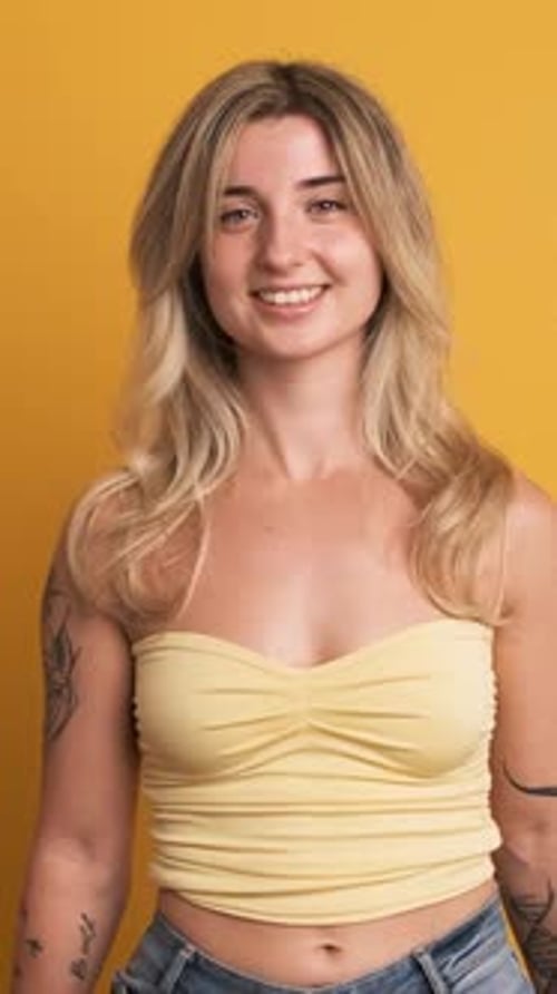 Woman Poses and Smiles in Yellow Background