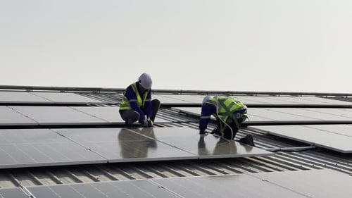 Technician installing solar cell. Installation and maintenance of solar cells on rooftop.