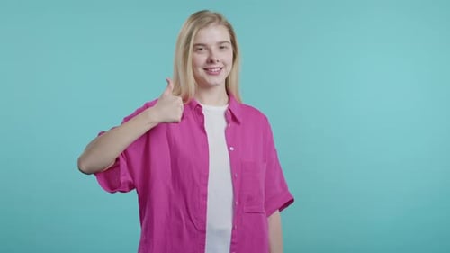 Blonde Woman Giving Thumbs Up on Blue Background