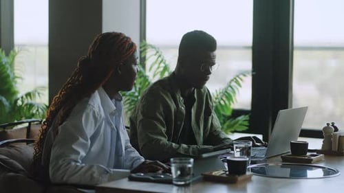 Two Professional Black Business Partners in the Cafe Working on Advanced Technological Devices