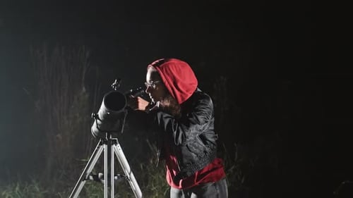 Woman Observing Night Sky with Telescope in Dark Field