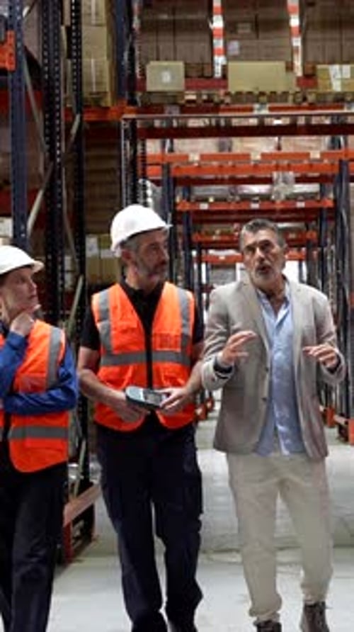 Warehouse Manager Discussing Logistics with Diverse Team of Workers