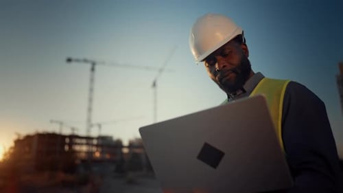 Black Man with White Helmet on Head Holding Modern Laptop Portrait of Foreman at Construction Site