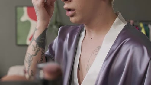 Queer Man Applying Foundation on Face with Sponge