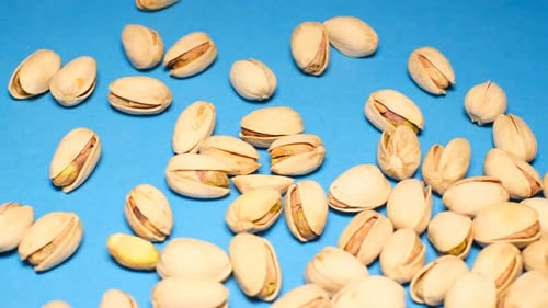 Pistachios Falling on a Blue Surface