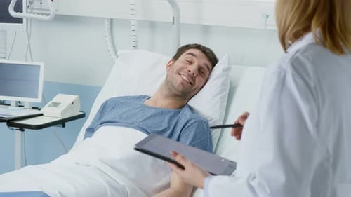 Doctor Consults Patient Lying in Hospital Bed