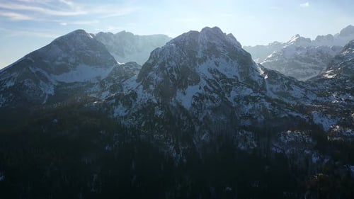 Monumentais montanhas nevadas épicas contra vista aérea do céu ensolarado