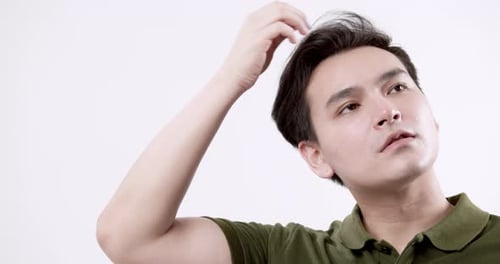 Man Scratching Hair in Front of White Background