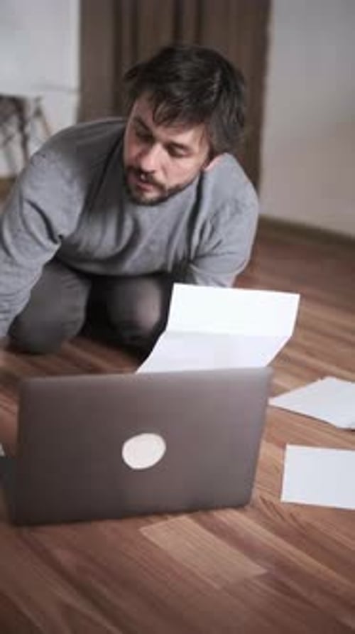 Man Paying Bills Online at Home Using Laptop and Documents Financial Management Remote Payment