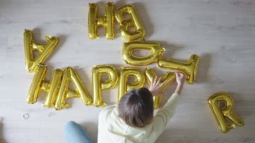 Woman Arranges Birthday Balloons with Playful Dog
