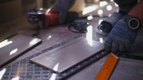 Man Cutting Tiles with Grinder for Home Improvement