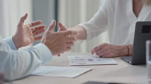 Businesspeople Discussing Charts Shaking Hands in Agreement