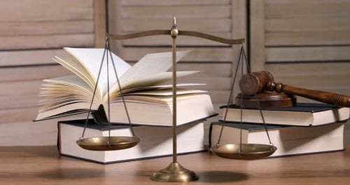Golden scales of justice, gavel and books on wooden table