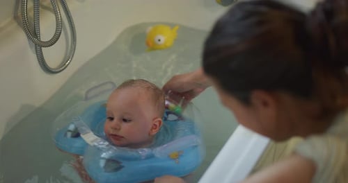 Baby Having Bath With Inflatable Neck Ring