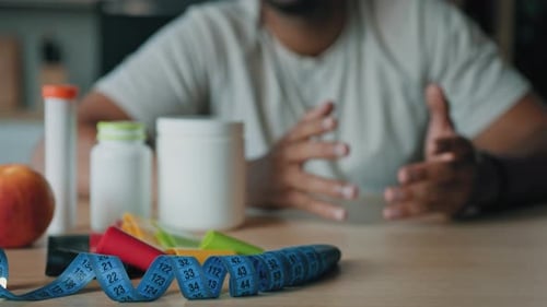 Supplements, Tape Measure, and Exercise Bands on Table