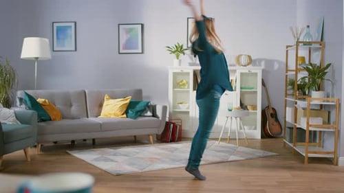 Cheerful woman dancing in her bright living room