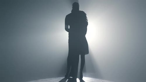 Romantisches Paar, das bei einer Verabredung im Innenbereich intim in der Dunkelheit tanzt