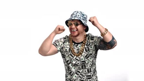 Joyful Rich Man with Clothes with Dollars Symbols and Golden Accessories Dancing in Studio Portrait